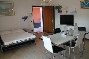 uma sala de estar com uma cama, uma mesa e cadeiras em CASA VACANZE DA RIKI APPARTAMENTO 2 em Peschiera del Garda
