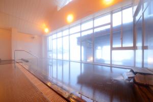 an empty gymnasium with a swimming pool in a building at Hotel Grand Mer Sankaiso in Ajigasawa