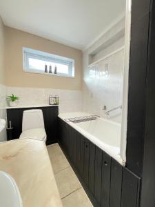 a bathroom with a bath tub and a toilet at Lovely Dog Friendly, 3 Bed Home Sleeps 8, with Parking & Fenced Garden WORK CONTRACTOR LEISURE, JASPER in Cambridge