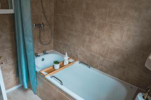 ein Badezimmer mit einer blauen Badewanne mit Dusche in der Unterkunft The Jade House - Cambridge Rental with Garden and BBQ, Near City Centre in Cambridge + 57 Fotos