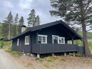 a small black house on the side of a road at Uvdalhytta - close to cross country and downhill skiing in Sønstebø