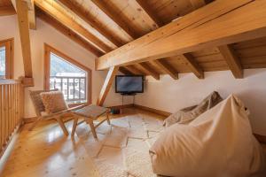 ein Wohnzimmer mit einem Sofa und einem TV in einem Haus in der Unterkunft Chalet Ski & in out - Flegere - Free Parking in Chamonix-Mont-Blanc
