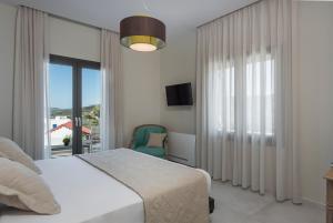 Un dormitorio con una cama y una ventana grande. en Villa Pirgos Luxury, en Kissamos 60 fotos más