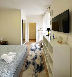 a bedroom with a bed and a flat screen tv at Extravaganza Room and Suite Apartment City Center in Cagliari