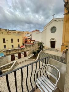 a church with a bench in front of a building at Extravaganza Room and Suite Apartment City Center in Cagliari