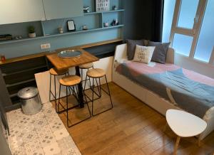 a small bedroom with a bed and a table and stools at Midoon guest - DUPLEX D'ARCHITECT PARIS 10ème in Paris