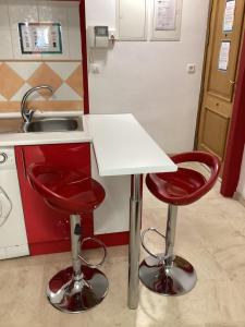 kuchnia z 2 czerwonymi stołkami i zlewem w obiekcie FUENGIROLA APARTAMENT SUN&BEACH w mieście Fuengirola