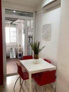 jadalnia z białym stołem i czerwonymi krzesłami w obiekcie FUENGIROLA APARTAMENT SUN&BEACH w mieście Fuengirola