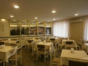 a dining room with white tables and white chairs at Dnepropetrovsk Hotel in Dnipro