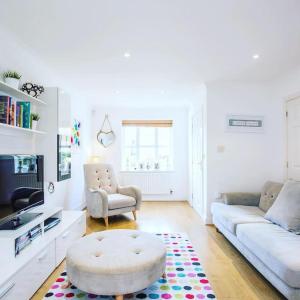 a living room with a couch and a coffee table at Beautiful 4 bedrooms house private parking & garden 7 min from tube in London