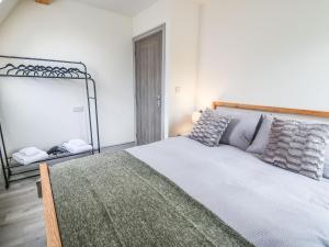 1 dormitorio con 1 cama grande y espejo en Hill Radnor - The Sheepfold, en Llandrindod Wells