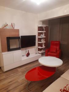 a living room with a table and a red chair at PISO RONDA in Granada