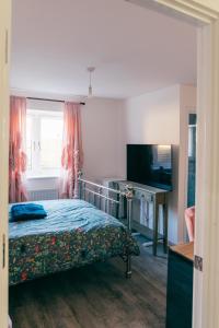 a bedroom with a bed and a flat screen tv at Oakley Place - Room A Deluxe Ensuite in Bristol