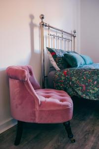 une chaise rouge assise à côté d'un lit dans l'établissement Oakley Place - Room A Deluxe Ensuite, à Bristol
