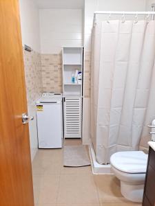 uma casa de banho com um WC e uma máquina de lavar e secar roupa em Fantástico loft cerca centro by Lofties em Terrassa