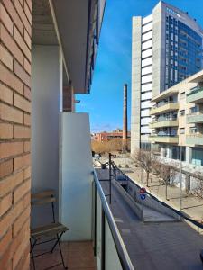 a room with a balcony with a view of a city at Fantástico loft cerca centro by Lofties in Terrassa