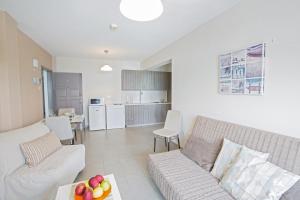 ein Wohnzimmer mit Sofa und Tisch in der Unterkunft Ayia Napa Holiday Apartment So2 in Ayia Napa