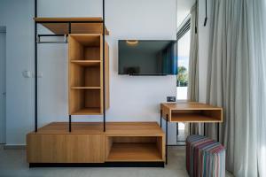a room with a tv and a desk and a room at Regency Boutique Hotel Holiday Suites in Paphos