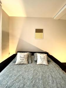 a bedroom with a bed with two pillows on it at Spacieux, Climatisé, Quartier Calme, Proche Château, Le Cocon De Joy in Carcassonne