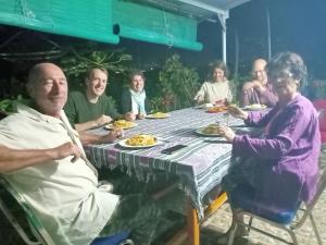 a group of people sitting around a table eating food at Hobbit Hill in Ruteng