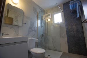 a bathroom with a shower and a toilet and a sink at Ayia Napa Holiday Apartment So7 in Ayia Napa +9 photos