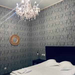 a bedroom with a bed and a chandelier at Vila Vidalis in Cluj-Napoca