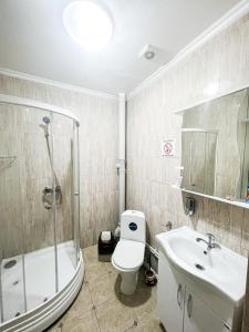 a bathroom with a toilet and a sink and a shower at Hotel ZeraVictoria in Atyraū