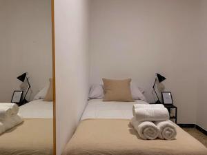 Spiegelreflexion eines Bettes mit Handtüchern darauf in der Unterkunft Can Jaume. Casa céntrica y cerca de la naturaleza. in Arbúcies