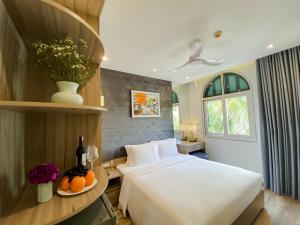 Anna Beach Phú Quốc في فو كووك: غرفة بالفندق سرير وطاولة مع برتقال