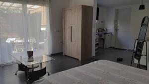 a room with a table and a cabinet and a kitchen at Un jour ailleurs in Saint-Pierre