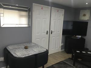 a room with a door and a table and a television at Ground Floor Hillview 2 bedroom Apartment in Brean