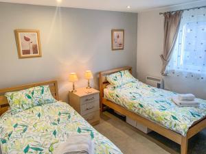 - une chambre avec 2 lits et une fenêtre dans l'établissement Beachlands, à Llanelli