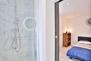 a bathroom with a shower and a bed in a room at Little Factory - T2 avec parking in Vierzon