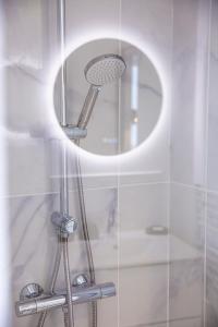 a shower with a round mirror in a bathroom at Little Factory - T2 avec parking in Vierzon