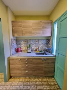 una cocina con armarios de madera y fregadero en Acogedora suite con ingreso independiente. en Jesús María