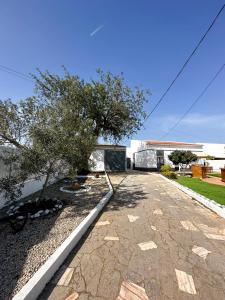 einen Steinweg mit einem Baum und einem Gebäude in der Unterkunft Sanzi Country House in Tavira