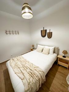 Un dormitorio con una gran cama blanca y una lámpara de araña. en Sanzi Country House, en Tavira