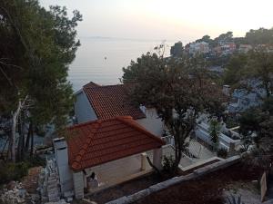 une maison avec un toit rouge et une vue sur l'océan dans l'établissement Ratak House, à Prižba