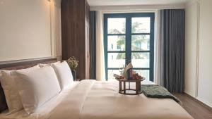 a bedroom with a large white bed with a window at Anna Beach Phú Quốc in Phú Quốc +81 photos