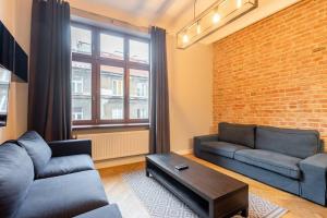 a living room with a couch and a brick wall at Riverside Kazimierz Castle 3 min p4you pl in Krakow