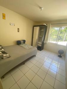 1 dormitorio con cama y ventana grande en Apartamento ao lado da UFSC, en Florianópolis