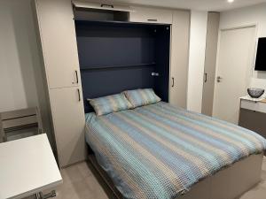 アルジェレス・シュル・メールにあるCYEL CATALANの小さなベッドルーム(ストライプ掛け布団付きのベッド付)