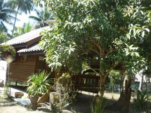 Pasai Beach Lodge في كو ياو نوي: منزل أمامه شجرة