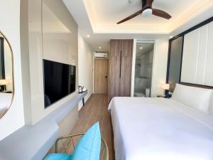 a bedroom with a large bed and a flat screen tv at Anna Beach Phú Quốc in Phú Quốc