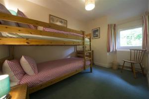 a bedroom with two bunk beds and a chair at Bank Top Cottage Coniston in Coniston