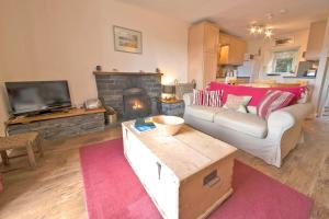 a living room with a couch and a fireplace at Bank Top Cottage Coniston in Coniston