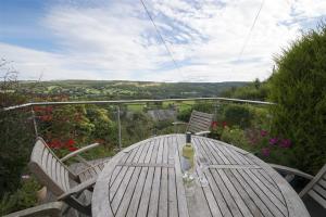 einen Holztisch mit einer Flasche Wein darauf. in der Unterkunft Bank Top Cottage Coniston in Coniston