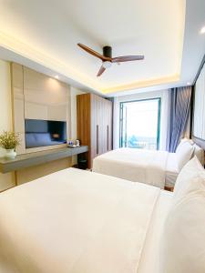1 dormitorio con 2 camas y TV de pantalla plana en Anna Beach Phú Quốc, en Phu Quoc