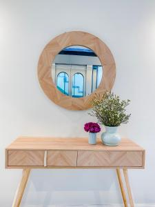 um espelho em cima de uma mesa de madeira com uma cómoda em Anna Beach Phú Quốc em Phu Quoc