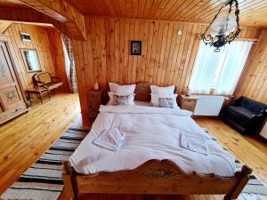 a bedroom with a large bed in a wooden room at Casa RAI in Predeal